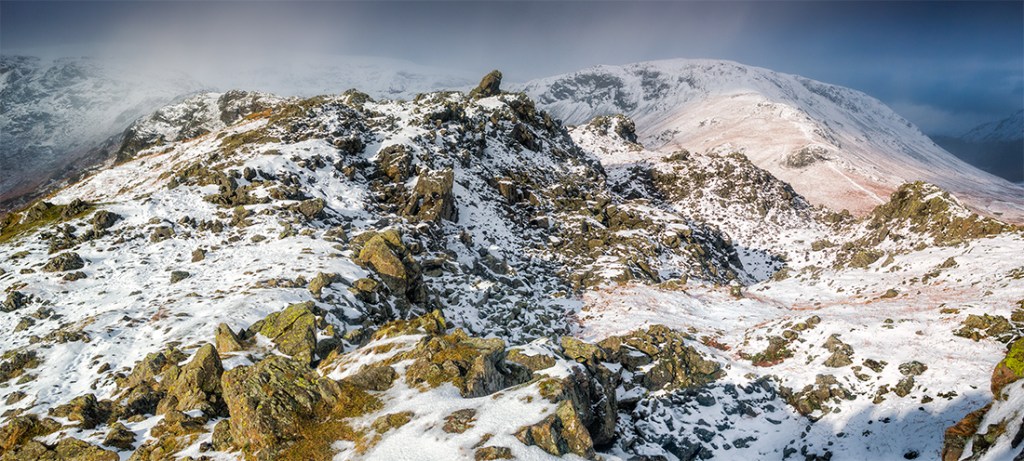 Three image stich of Helm Crag with approaching snow storm. Canon G16.